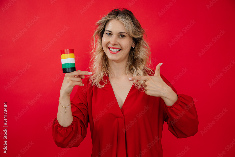 blonde beautiful woman holding in hand roll set of duct Insulation tape on red background blonde beautiful woman holding in hand roll set of duct Insulation tape on red background