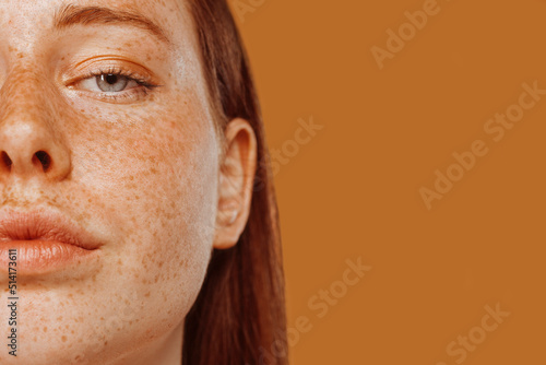Canvastavla Close-up portrait of half face red-haired girl with freckle and blue eye