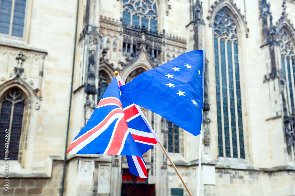 Flying Flags of the United Kingdom and the European Union. UK Flag and EU Flag with Building Church facade background. 