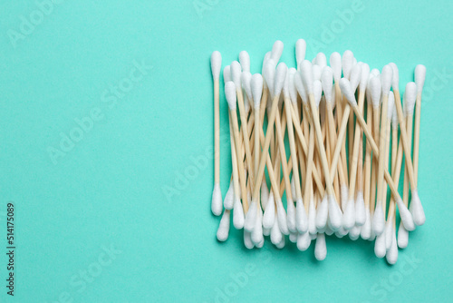 Heap of cotton buds on turquoise background, top view. Space for text © New Africa