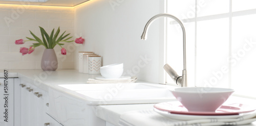 Beautiful ceramic dishware and bouquet on countertop in kitchen. Banner design