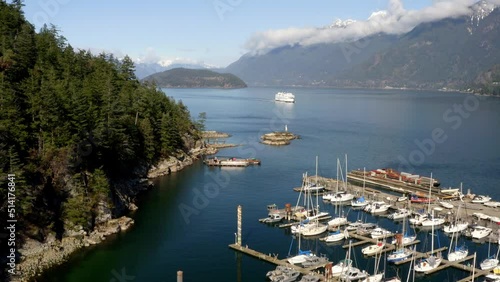 Moored Rental Boats And Fishing Charter Of Sewell's Marina In Horseshoe Bay, BC, West Vancouver, Canada With Sight Of A Cruising BC Ferry. Forward Drone Shot photo