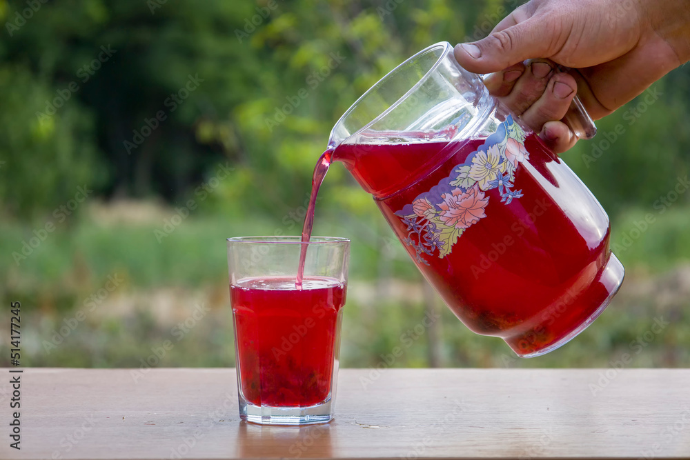 Pouring red compote of berries in a glass. Pouring red compote of berries in a glass.