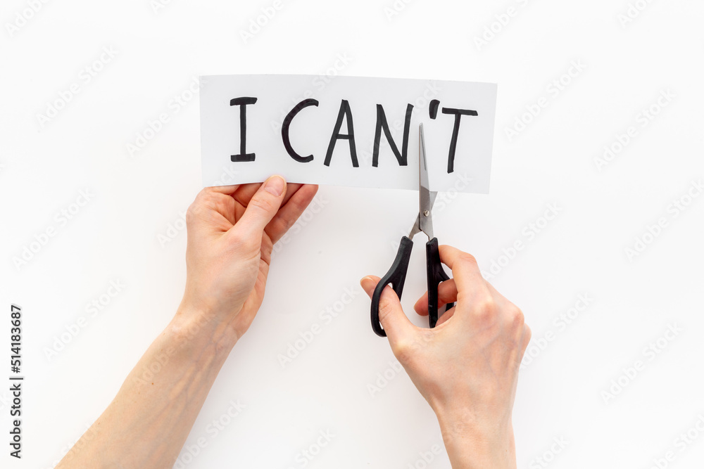 Hands cutting card with text I cannot into I can. Motivation concept Hands cutting card with text I cannot into I can. Motivation concept