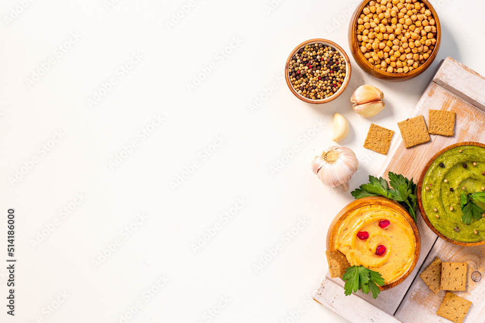 Flatlay of hummus with snacks and herbs. Vegan food background Flatlay of hummus with snacks and herbs. Vegan food background