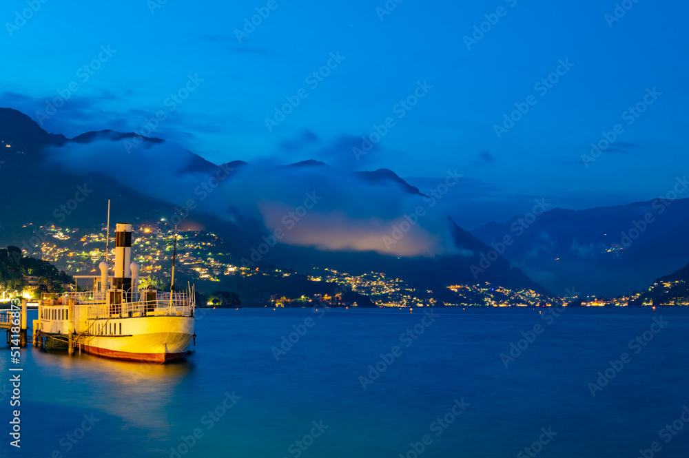 The panorama of Lake Como, photographed from Villa Olmo, with an ancient moored boat.
