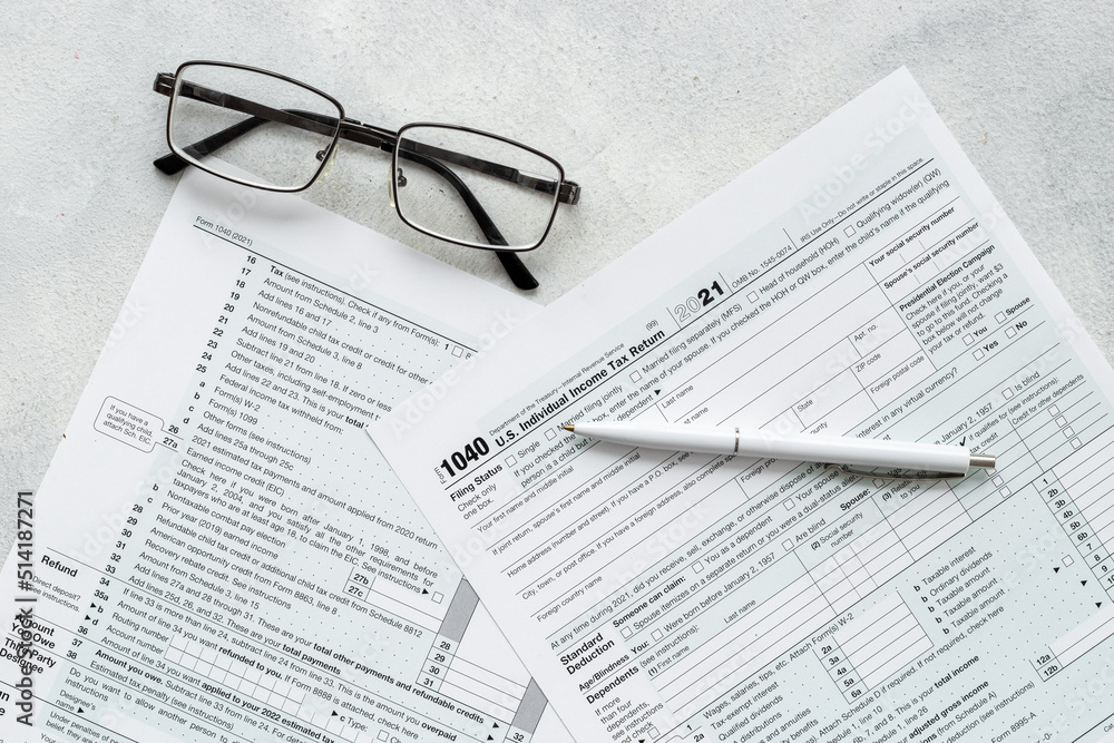 Businessman table with US tax form and pen. Culculating and payment of taxes Businessman table with US tax form and pen. Culculating and payment of taxes