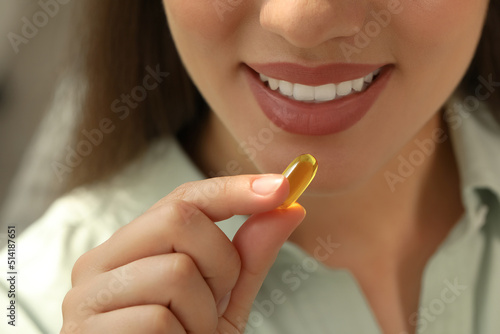 Young woman taking dietary supplement pill  closeup