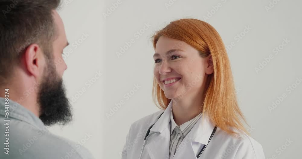 Woman doctor smiles and consults mature man in office Woman doctor smiles and consults mature man in office