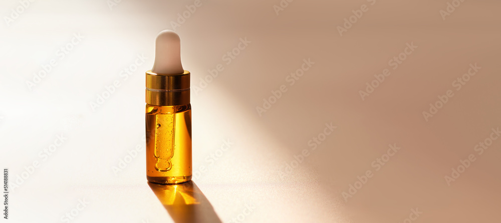 Cosmetic amber glass dropper bottle with oil, serum or fruit peeling in the sunlight on beige background with soft focus. Beauty product presentation, natural banner. Front. Mockup concept Cosmetic amber glass dropper bottle with oil, serum or fruit peeling in the sunlight on beige background with soft focus. Beauty product presentation, natural banner. Front. Mockup concept