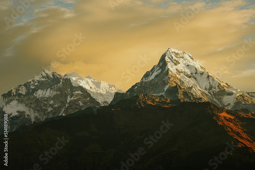 Warm pink and orange dramatic sunrise light over Annapurna mountain range with beautiful clouds, view from Poon hill in Himalayas, Nepal