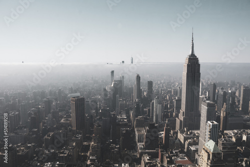 An aerial view of foggy New York City cityscape with the Empire State Building and One World Trade Center