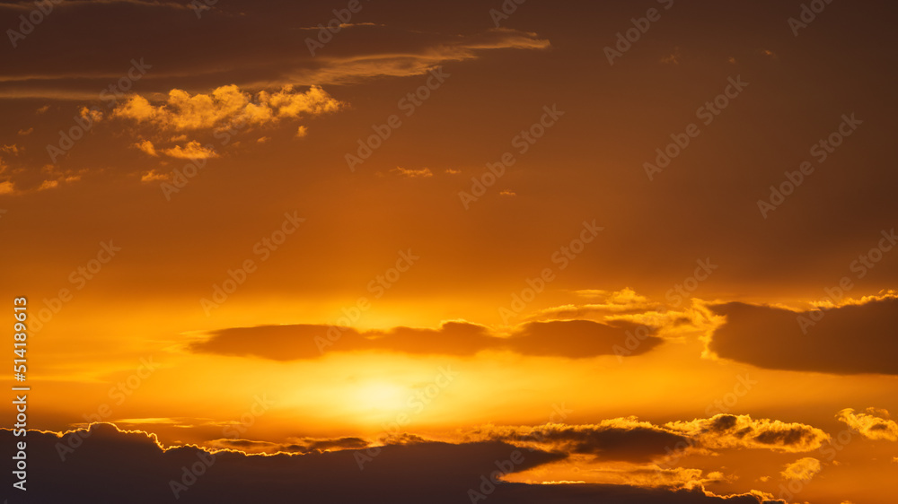 Background created from the orange sky with some clouds at sunset.