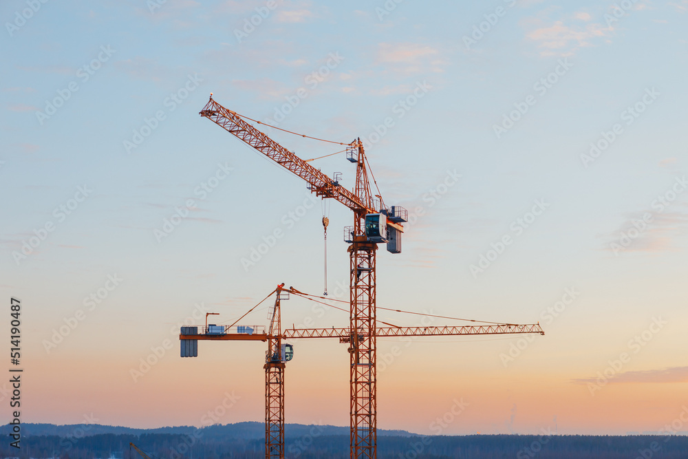 building cranes on the construction site at sunset background building cranes on the construction site at sunset background