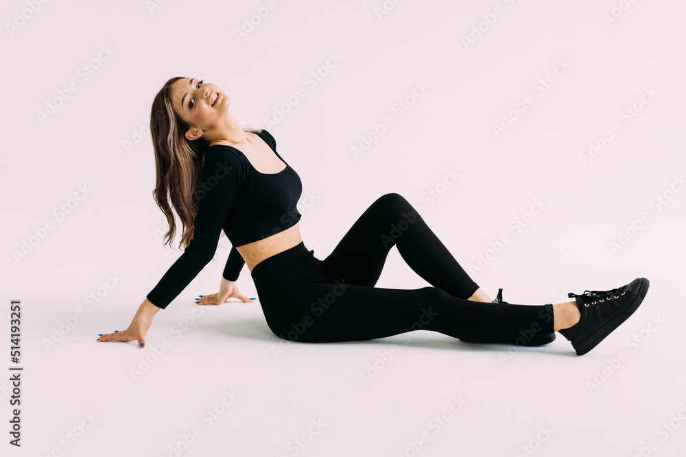 Smiling woman sitting on the floor isolated on a white background. Smiling woman sitting on the floor isolated on a white background.