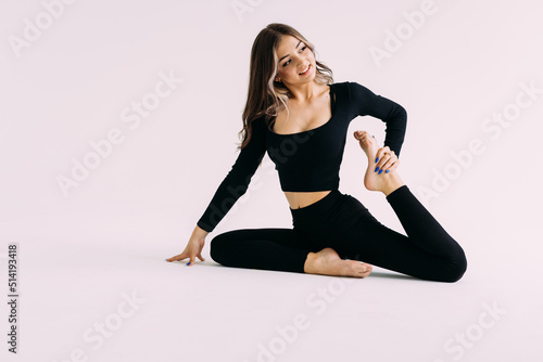 Portrait of sports woman stretching legs on the floor isolated on a white background