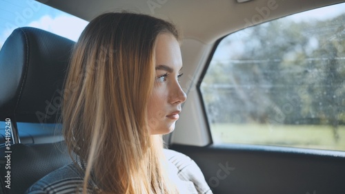 A young girl rides in a car in the back seat. © Довидович Михаил