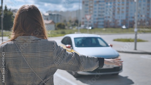 Fényképezés A girl is waving to a cab in the city.