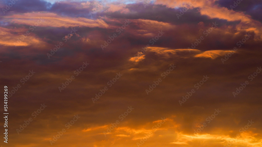 Ciel rougeoyant pendant un coucher de soleil, sous des nuages de haute altitude