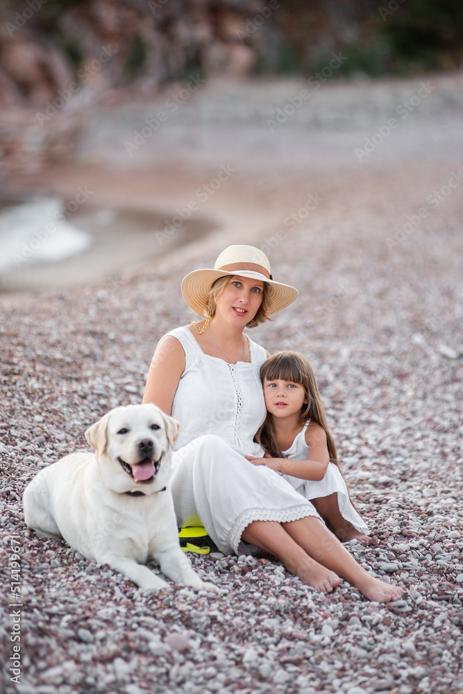 Pregnant mother with little daughter are walking along the sand of the beach near the sea with golden retriever. Millennial woman holds dog on leash, girl by the hand. Concept of traveling with pets Pregnant mother with little daughter are walking along the sand of the beach near the sea with golden retriever. Millennial woman holds dog on leash, girl by the hand. Concept of traveling with pets