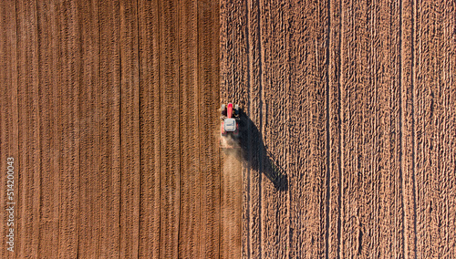 Tracteur vu du ciel passant le rouleau agricole. Tracteur dans un champ de terre.
