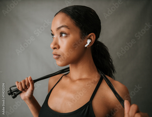 Close up Multiethnic female listening to music on her ear pods 