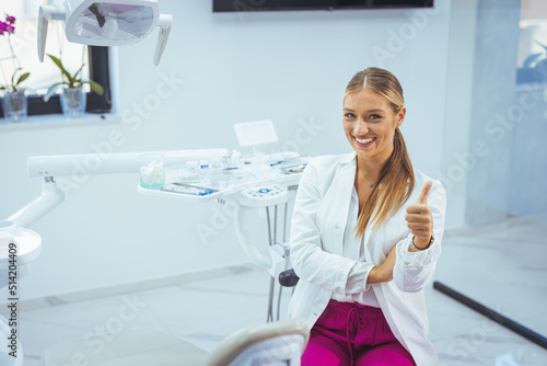 Portrait of a Caucasian woman dentist  sitting in her office next to a dentist chair  smiling. Portrait of female dentist. She standing at her office. Healthcare and medicine concept