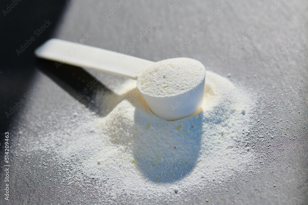 Sport food supplement powder with natural beige background and props. Still life: supplement, creatine, hmb, bcaa, amino acid or vitamine in a white scoop. Sport nutrition and healthy life concept Sport food supplement powder with natural beige background and props. Still life: supplement, creatine, hmb, bcaa, amino acid or vitamine in a white scoop. Sport nutrition and healthy life concept