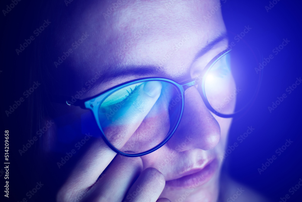 Tired woman in glasses works on Migraine or headache after