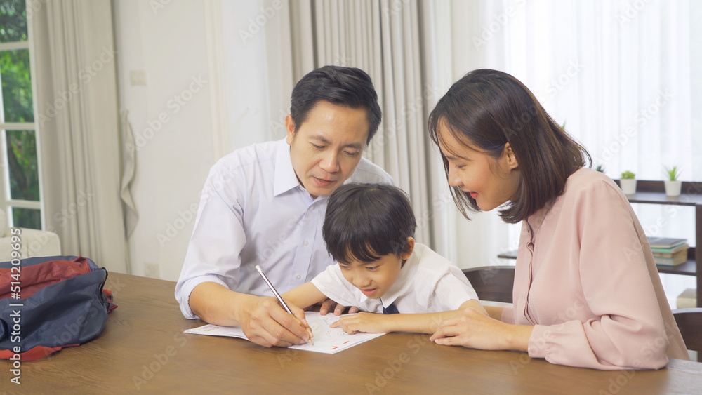 Portrait of happy smiling Asian Family. A student studying homework from school at home or house in family relationship. Love of father, mother, and son. People lifestyle. Education activity. Portrait of happy smiling Asian Family. A student studying homework from school at home or house in family relationship. Love of father, mother, and son. People lifestyle. Education activity.