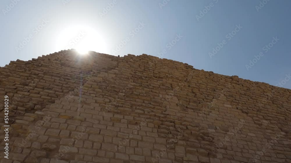 Low angle view sunbeam through top of Stone pyramid against blue sky in Saqqara Necropolis, Egypt Low angle view sunbeam through top of Stone pyramid against blue sky in Saqqara Necropolis, Egypt