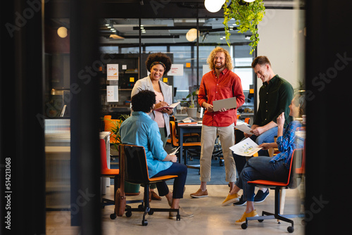 Multiracial creative businessmen and businesswomen discussing during meeting in office