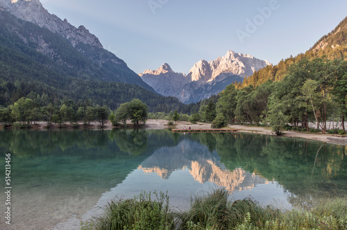 Girls doing Yoga on the wooden pier at lake Jasna in Kranjska Gora. A perfect way to start the day with amazing reflections of the mountains in the lake.