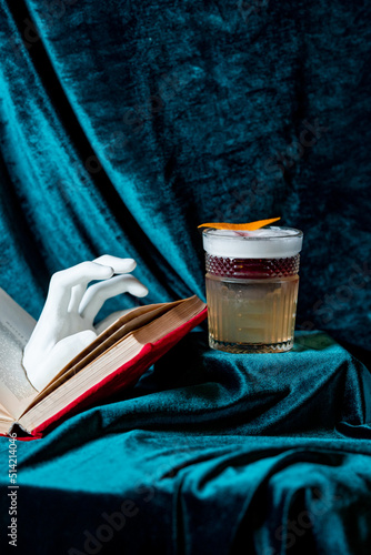 alcohol coctail with book and hand photo