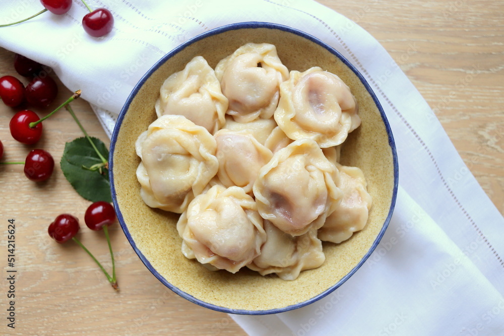 delicious sweet dumplings with cherries in a clay plate close-up on the table selective focus delicious sweet dumplings with cherries in a clay plate close-up on the table selective focus