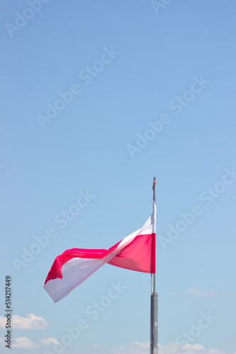 Polish flag against the blue sky.