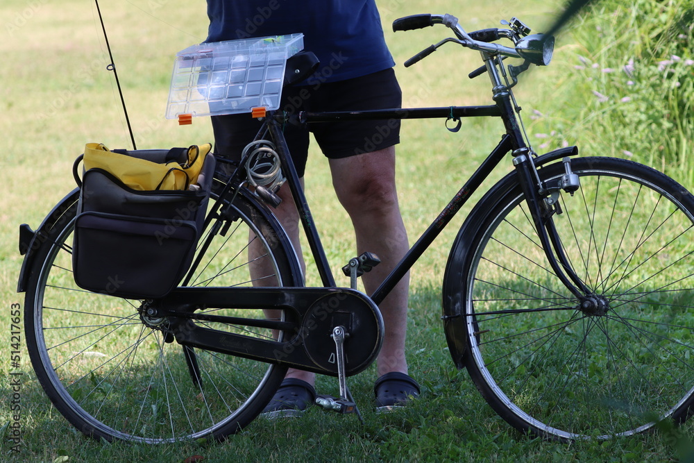 elderly person on bicycle inserts bait to fishing hook- elderly person on bicycle inserts bait to fishing hook-