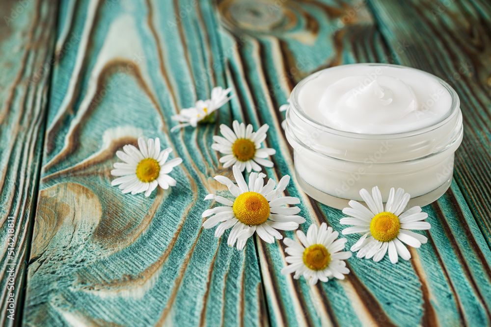 Chamomile cream in glass jar on the wooden background Chamomile cream in glass jar on the wooden background