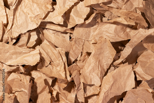 Multiple pieces of torn brown crumpled, wrinkled recycle craft paper background texture, top view