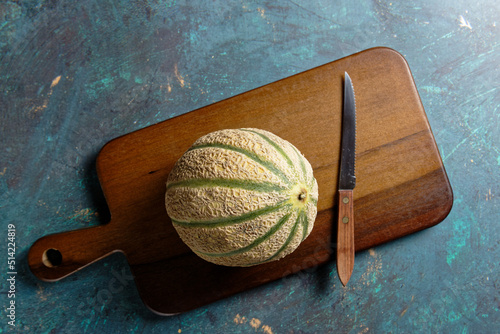 Overhead view of a cantaloupe melon, on a wooden cutting board. photo