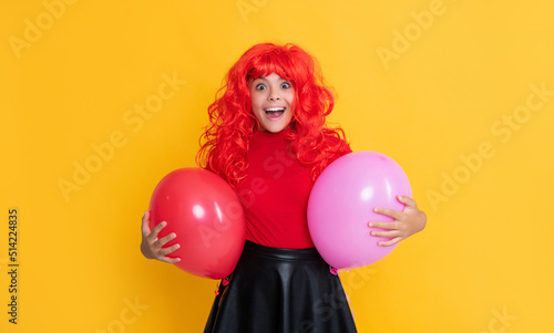 shocked teen child with party balloon on yellow background © be free