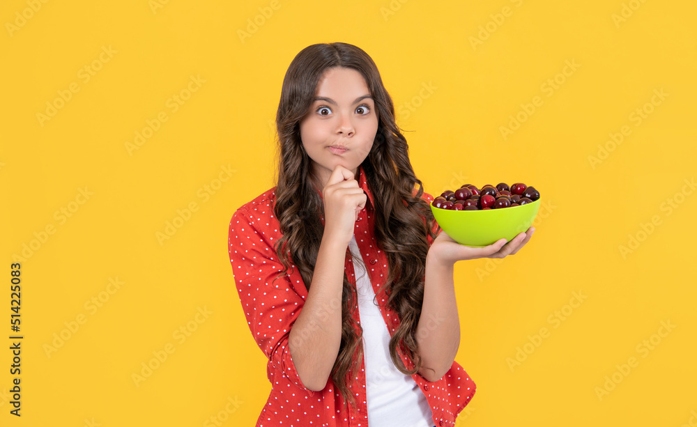 thinking teen girl hold cherry bowl on yellow background
