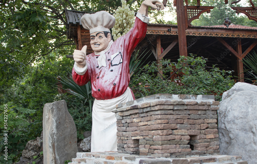 Obraz premium plaster figure of the cook at the entrance to the cafe