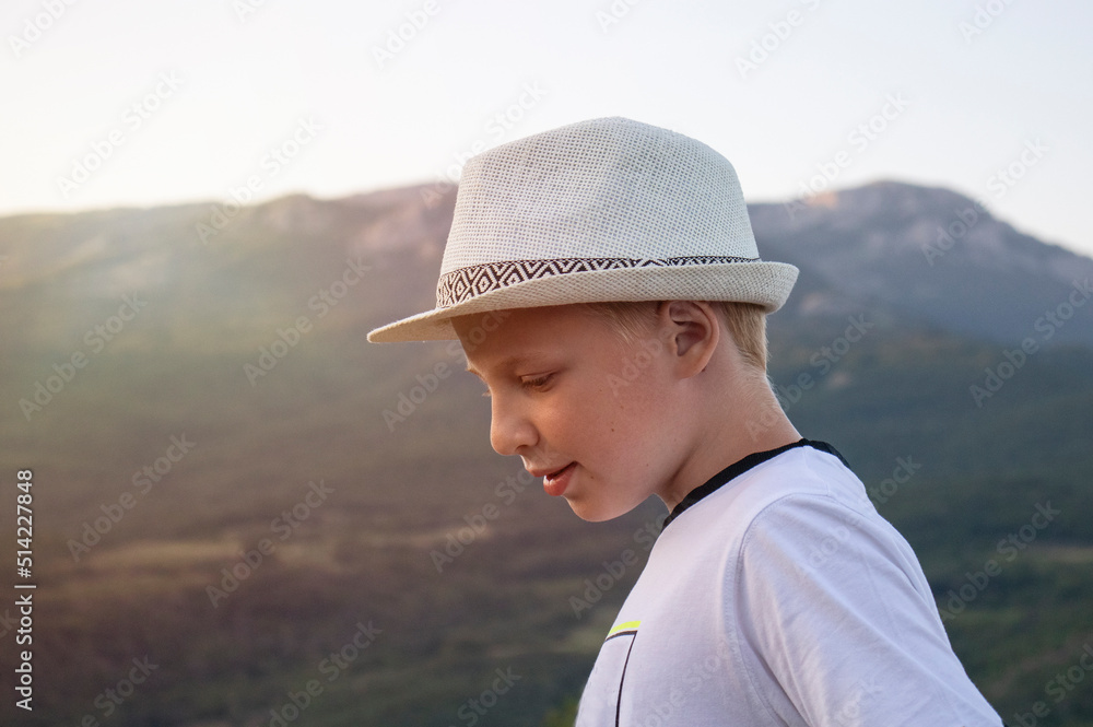 boy teenager walks in the summer in the mountains
