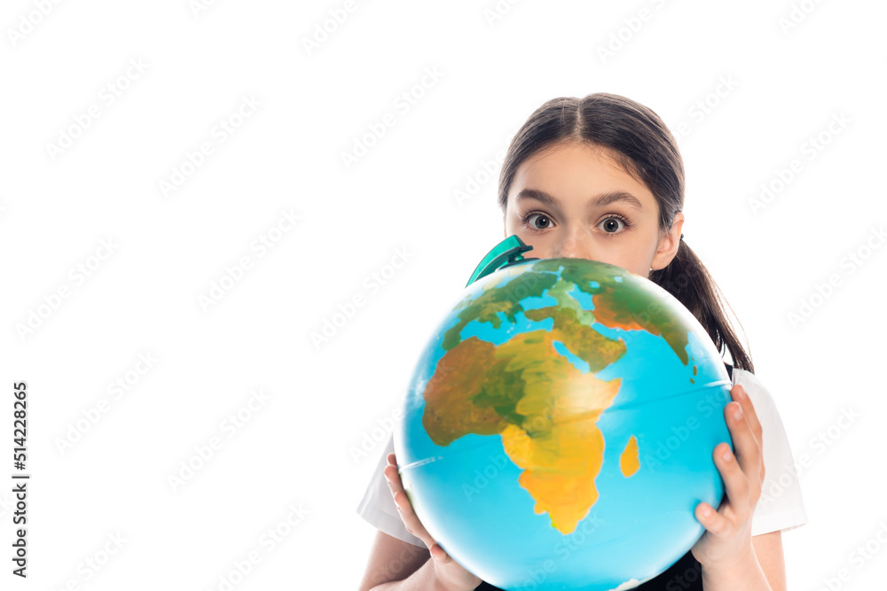 Schoolkid holding globe near face and looking at camera isolated on white. Schoolkid holding globe near face and looking at camera isolated on white.
