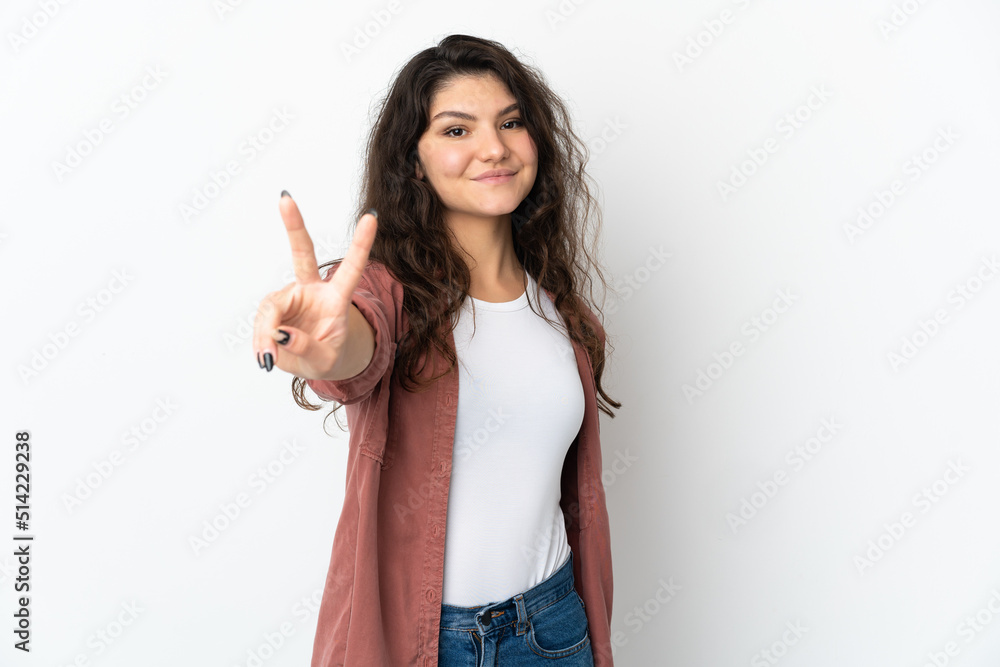 Teenager Russian girl isolated on white background smiling and showing victory sign Teenager Russian girl isolated on white background smiling and showing victory sign