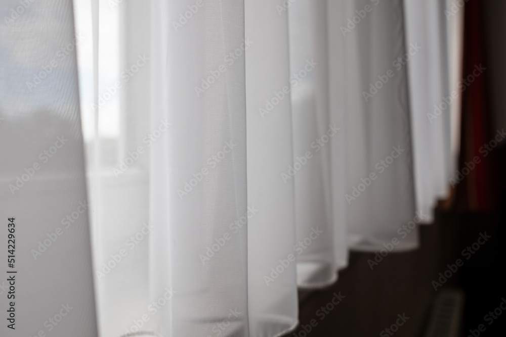 White transparent curtain closes the window, indoors. 