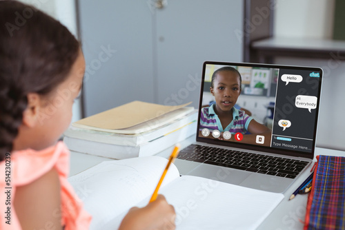 Biracial girl looking at laptop screen with african american student speaking in online lecture