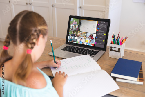 Obraz na plátně Caucasian girl writing notes in book given during online lecture over video call