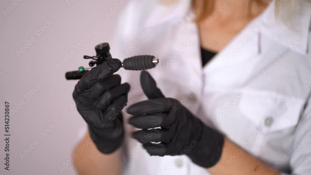 hand tattoo artist with the tattoo machine on a white background. hand tattoo artist with the tattoo machine on a white background.